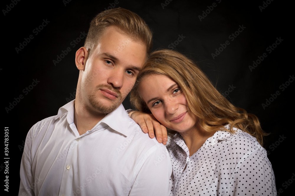 Young beautiful couple studio portrait on black background. Young beautiful couple studio portrait on black background.