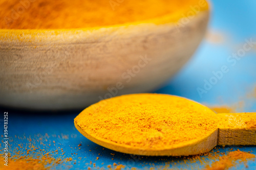 ground turmeric on blue background photo