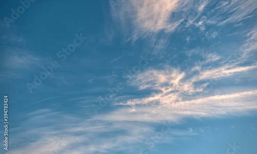 Beautiful evening blue sky, with white cirrus clouds of different shapes