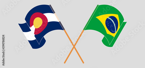Crossed and waving flags of Brazil and The State of Colorado