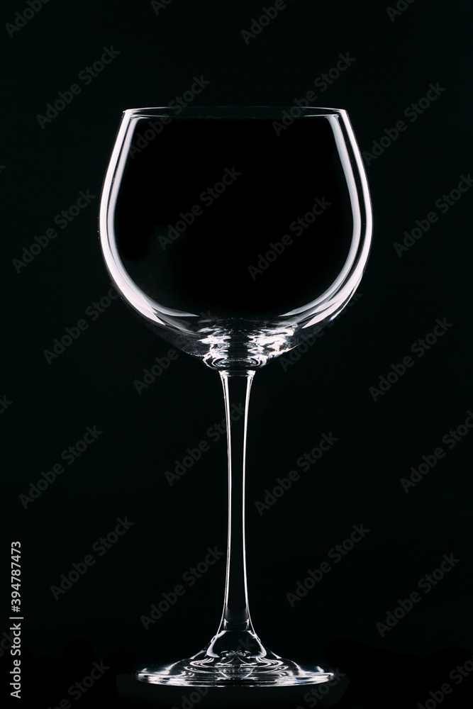 Large glass goblet with beautiful highlights on a black background. Wine glass. Isolate. Large glass goblet with beautiful highlights on a black background. Wine glass. Isolate.