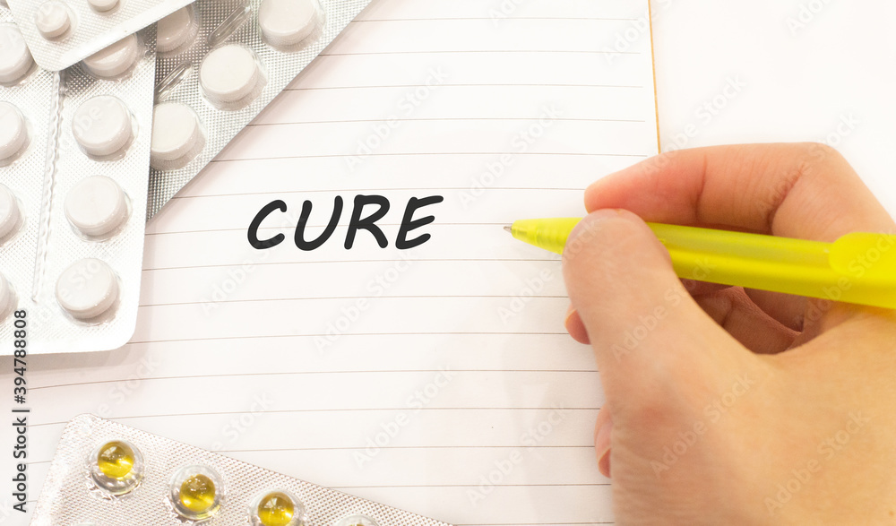Text cure on white background. There are various pills and vitamins around. Medical concept Text cure on white background. There are various pills and vitamins around. Medical concept