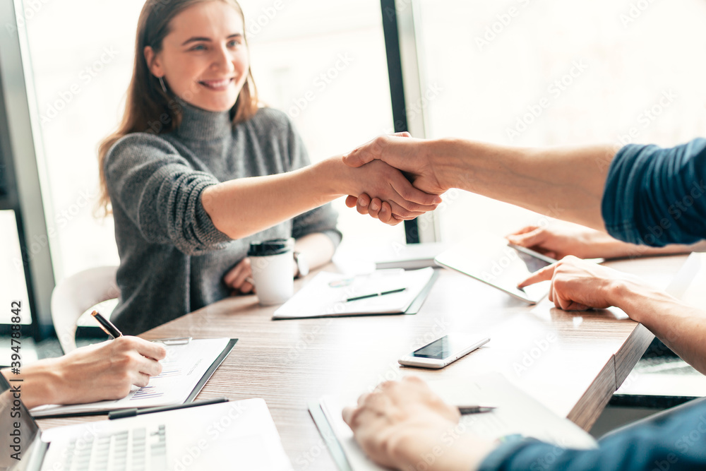 Fototapeta premium close up. young business woman shaking hands with her business partner.
