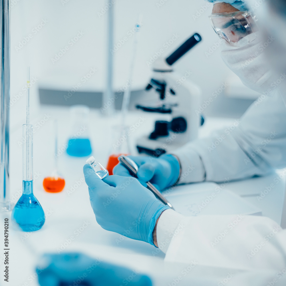 close up. a scientist writing down the formula for a new drug . close up. a scientist writing down the formula for a new drug .