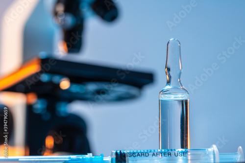 Medical vial with medication near microscope photo