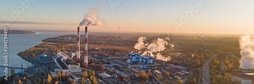 Factory chimneys producing smoke at sunrise, aerial view. Concept of air pollution, environment and ecology crisis, climate change, global warming.