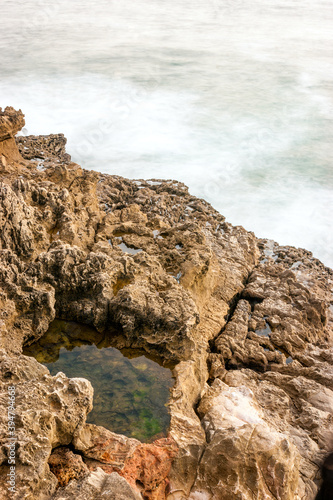 Hole with water in the rock formations next to the Atlantic Ocean near Hell's Mouth (In Portuguese Boca do Inferno) in Cascais, Portugal