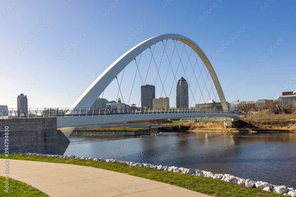 Looking at the Des Moines Iowa skyline through the Woman of Achievement Bridge over the Des Moines River during daytime.