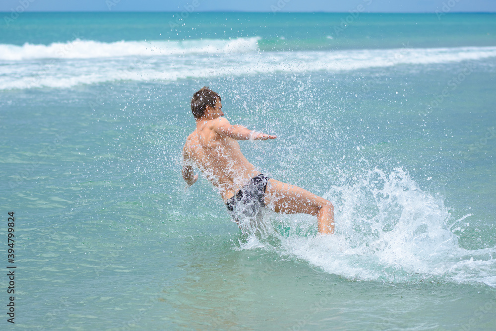 A man accelerating from the shore jumps sideways into the sea water at the resort