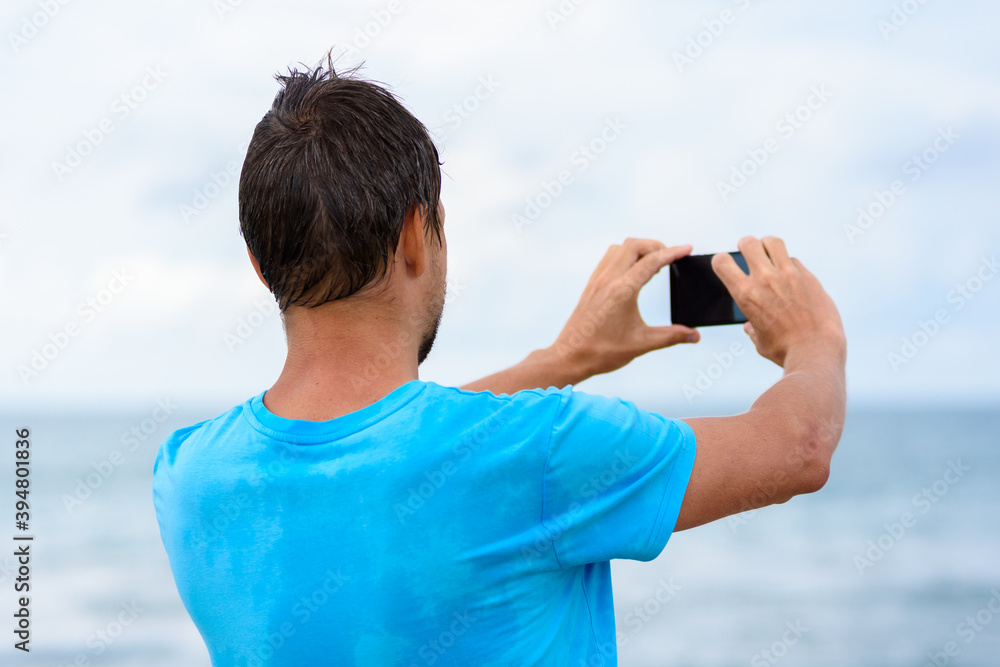 Man photographs the seascape on a mobile phone