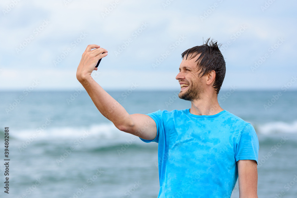 A man on vacation takes pictures of himself on a mobile phone A man on vacation takes pictures of himself on a mobile phone