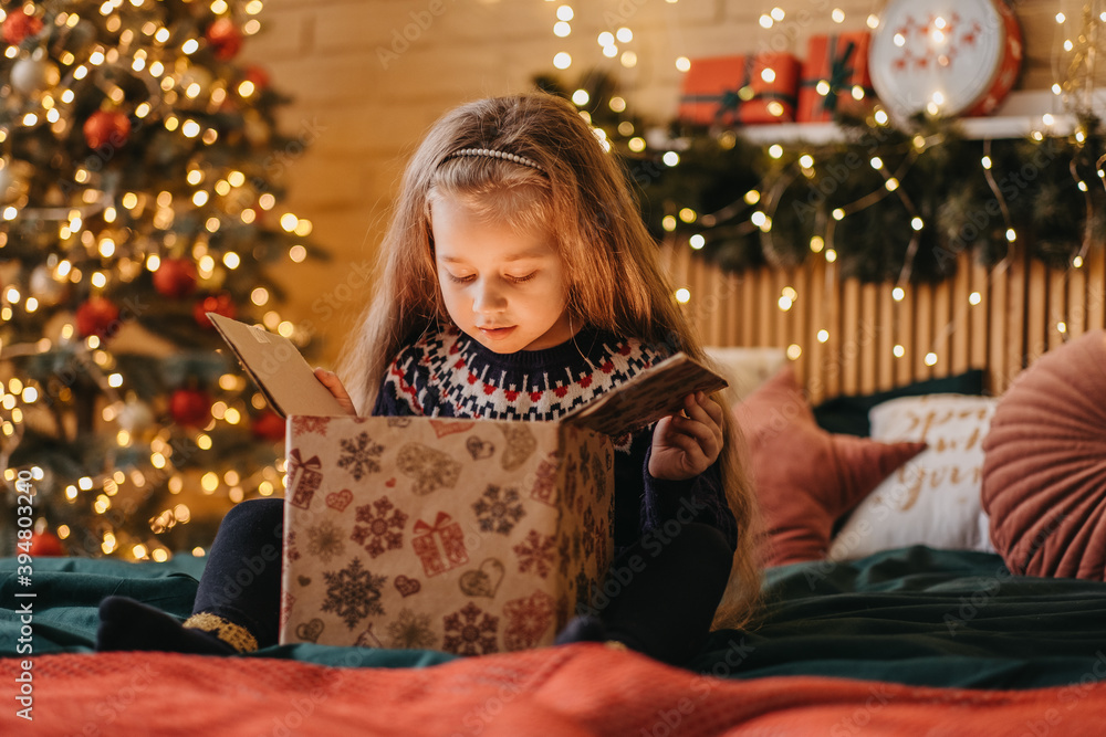 Excited girl opens gift box from Santa Claus, happy childhood, holiday celebration, Christmas miracle Excited girl opens gift box from Santa Claus, happy childhood, holiday celebration, Christmas miracle