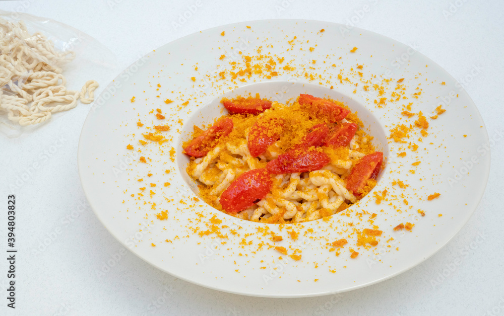 Fresh lorighittas semolina pasta with grated bottarga and cherry tomatoes Fresh lorighittas semolina pasta with grated bottarga and cherry tomatoes
