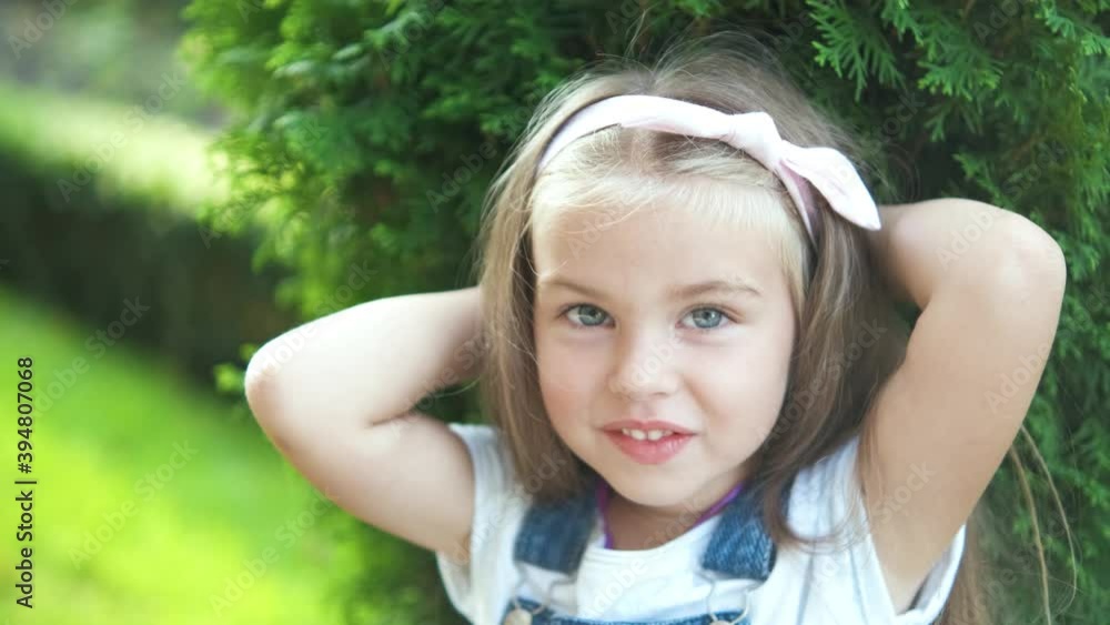Portrait of pretty child girl standing in summer park looking in camera smiling happily. Portrait of pretty child girl standing in summer park looking in camera smiling happily.