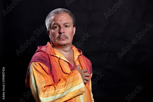 Middle aged man in bright orange clothe studio portrait