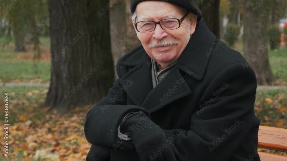 Handsome elderly senior man looking at camera in park Handsome elderly senior man looking at camera in park