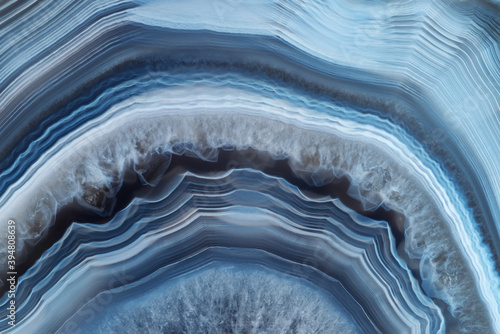 Full-screen close-up texture of translucent white-blue agate with a concentric pattern and ghostly quartz crystals photo