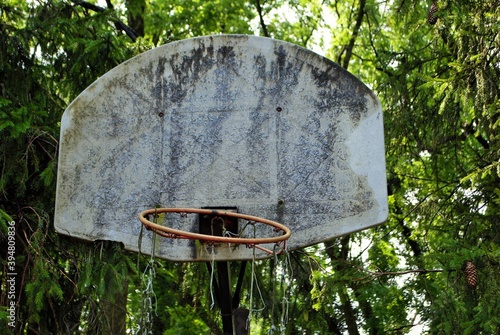 very old abandoned basketball hoop that is falling apart photo