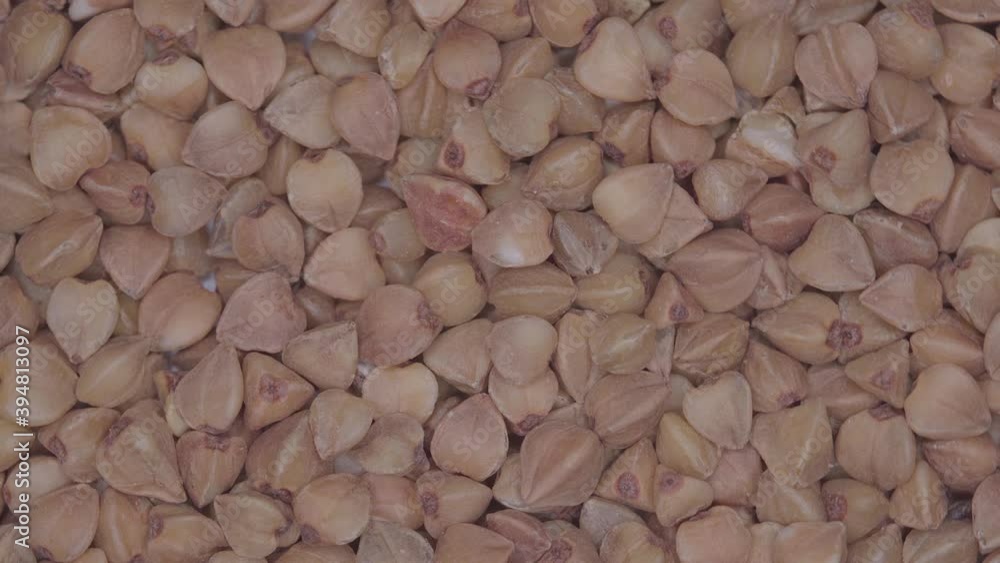 Whole grains of brown buckwheat rotating. Close up view Whole grains of brown buckwheat rotating. Close up view