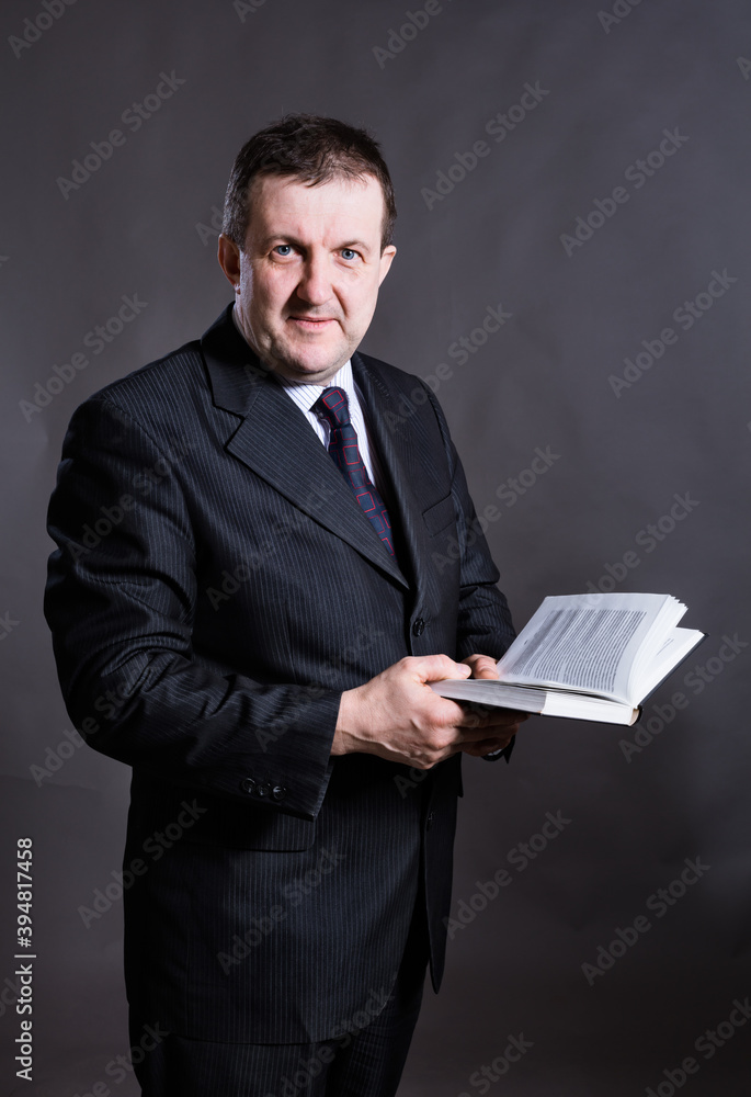 Middle aged solid tutor with book studio portrait. Middle aged solid tutor with book studio portrait.