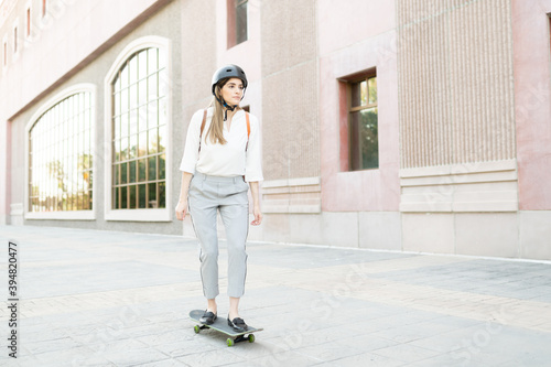 Professional woman in top of a skateboard outside an office building