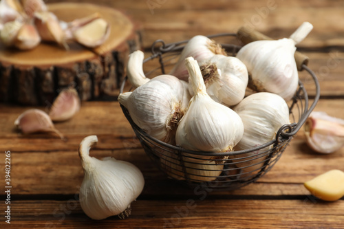 Fresh organic garlic in basket on wooden table