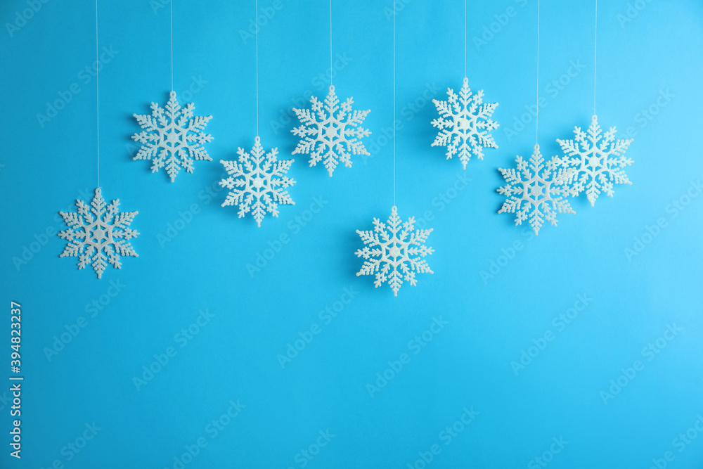 Beautiful decorative snowflakes hanging on light blue background