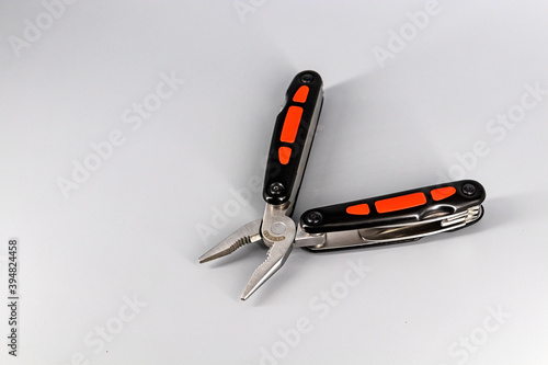 Multipurpose Tool - Multipurpose pliers, knife, screwdriver, hook, saw. photo