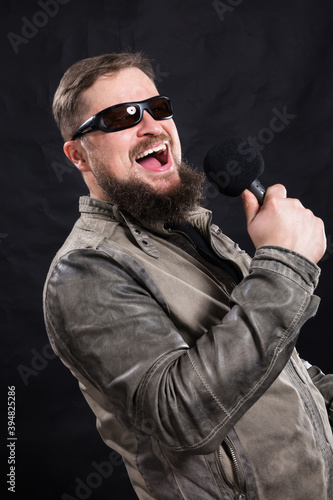 Bearded emotional rock singer with microphone studio portrait. photo