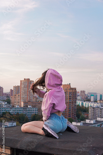 
girl in pink hoodie sitting on the roof
