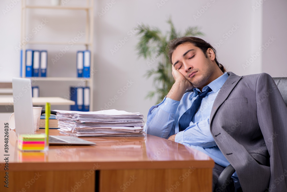 Young male employee sleeping in the office Young male employee sleeping in the office