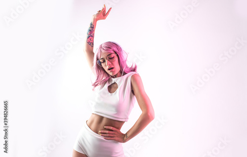 Fototapeta Naklejka Na Ścianę i Meble -  Young woman with pink hair dancing and having fun