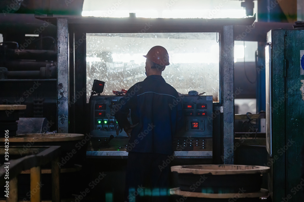 industrial worker operating CNC machinery in metallurgical factory industrial worker operating CNC machinery in metallurgical factory