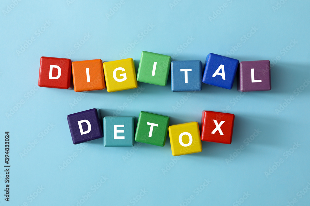 Colorful cubes with phrase DIGITAL DETOX on light blue background, flat lay Colorful cubes with phrase DIGITAL DETOX on light blue background, flat lay