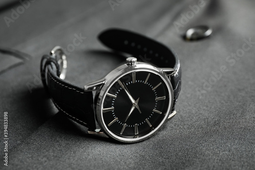 Luxury wrist watch on black fabric, closeup