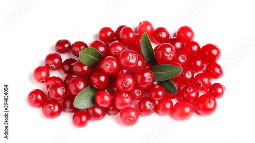 Pile of fresh cranberries with green leaves on white background, top view