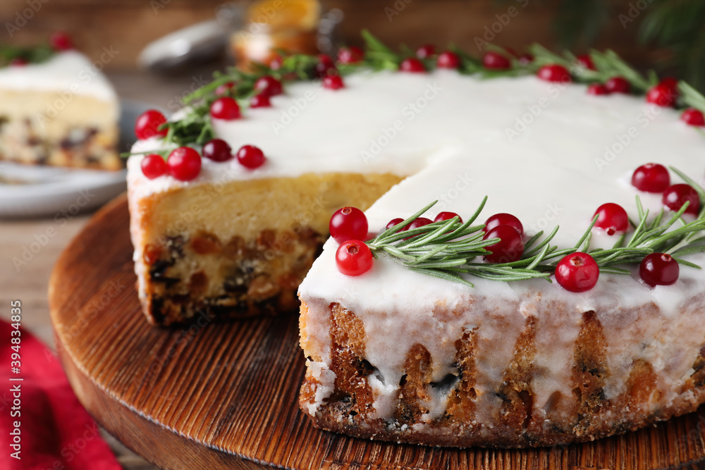 Traditional Christmas cake decorated with rosemary and cranberries on tray, closeup Traditional Christmas cake decorated with rosemary and cranberries on tray, closeup