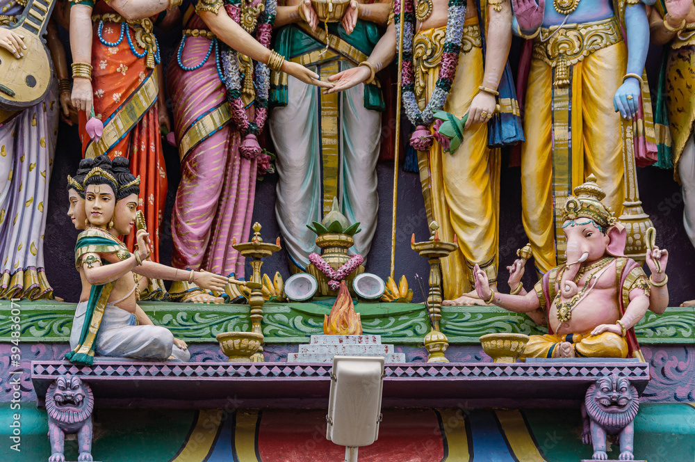 Fototapeta premium Kadirampura, Karnataka, India - November 4, 2013: Sri Murugan Temple. Colorful statues on facade in front: closeup of Puja celebrated by Ganesha and Brahma deities to honor Murugan wedding.