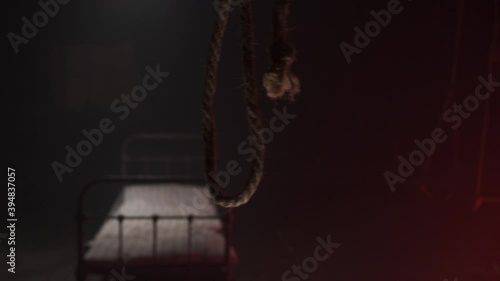 scary noose gallows for execution swings in dark against background of white metall bed in dark hospital or hangar sinister. Horror movie concept. bed with old mattress for corpse after hanging. photo