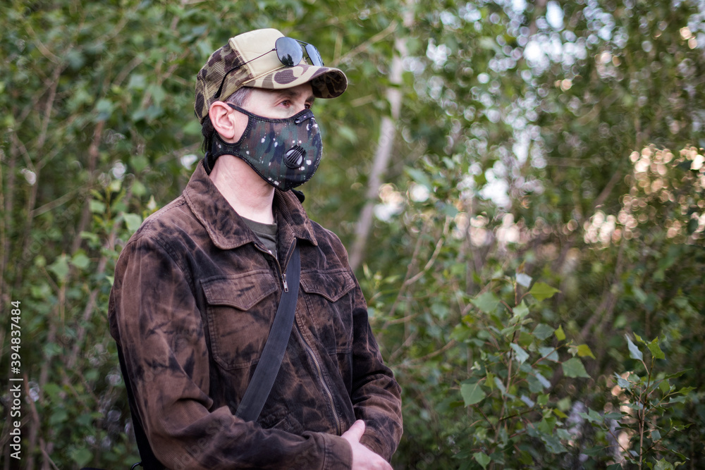 Obraz premium A man wearing respirator mask and a cap outdoors.