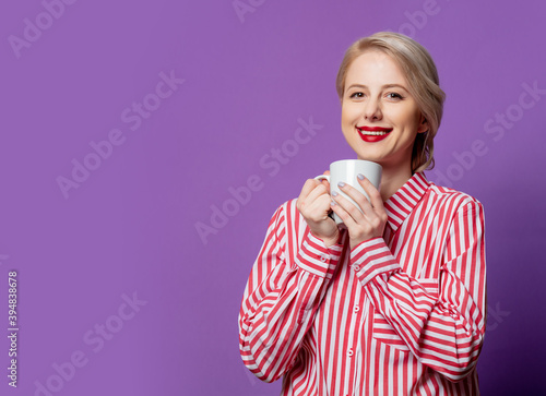 Beautiful woman in red striped shirt with cup of coffee