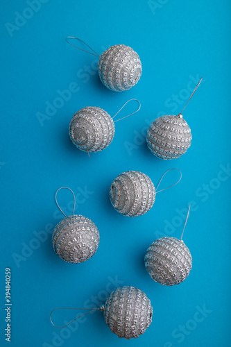 Christmas or New Year composition. Decorations, silver balls, on a blue background. Top view, copy space.