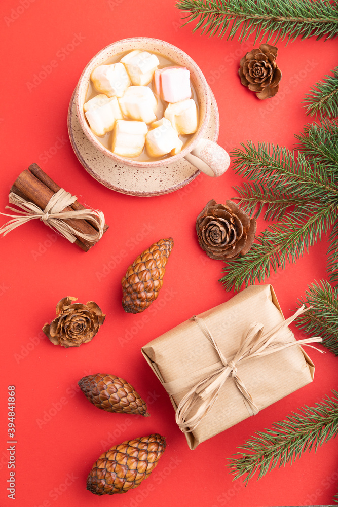 Christmas or New Year composition. Decorations, cones, fir and spruce branches, cup of coffee, on a red background. Top view.