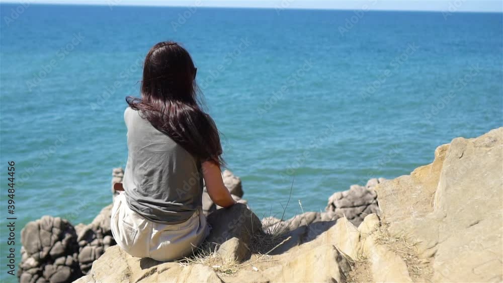 Tourist woman outdoor on edge of cliff seashore Tourist woman outdoor on edge of cliff seashore