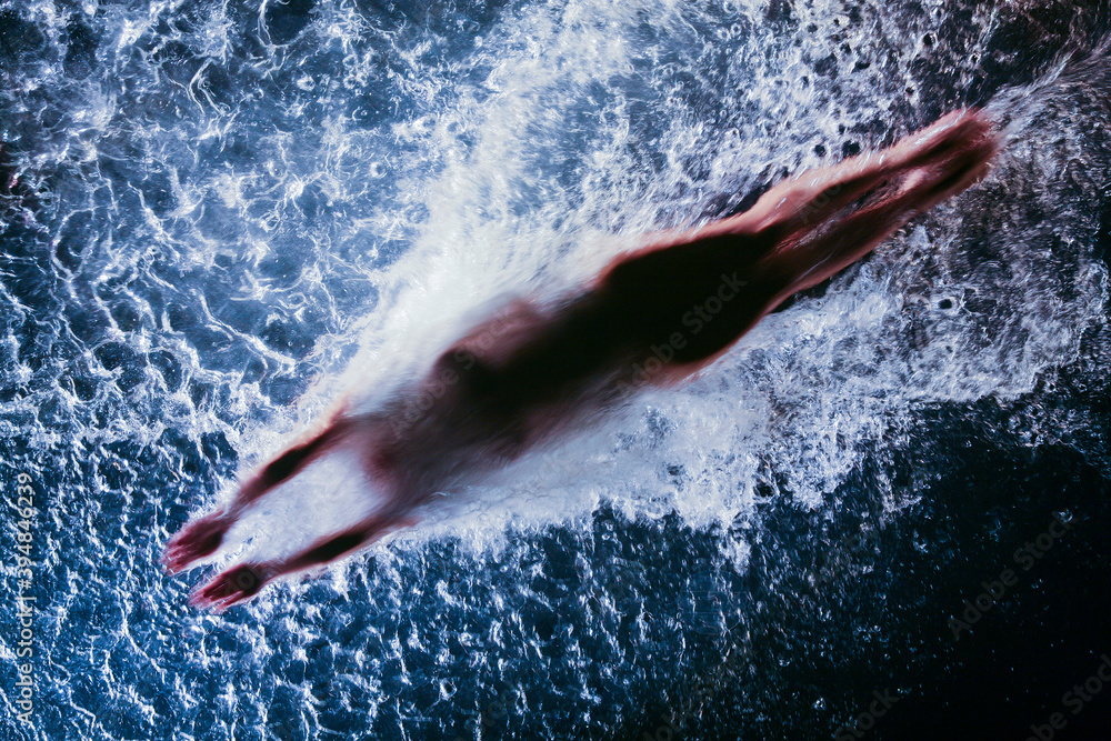 Body plunging in swimming pool from below Stock Photo | Adobe Stock