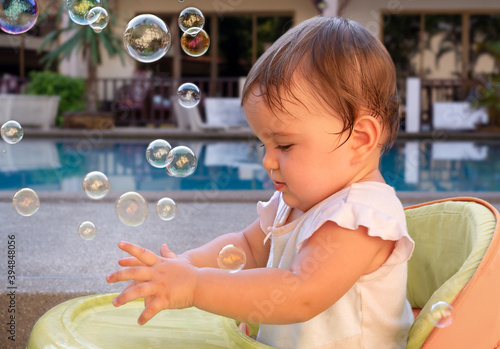 cute baby catching soap bubbles outside