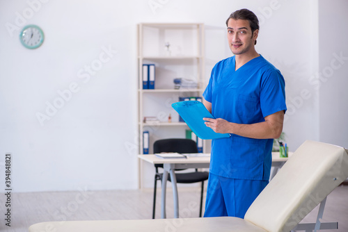 Young male doctor taking notes at the hospital