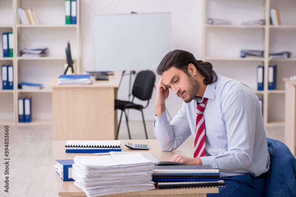 Fototapeta premium Young male employee unhappy with excessive work