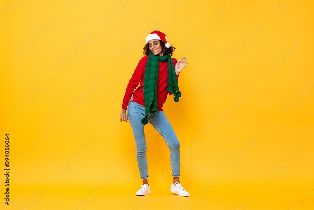 Full length portrait of joyful happy woman in Christmas attire dancing on isolated yellow studio background Full length portrait of joyful happy woman in Christmas attire dancing on isolated yellow studio background