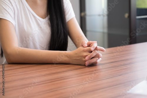 Close up woman hand on wooden table background.